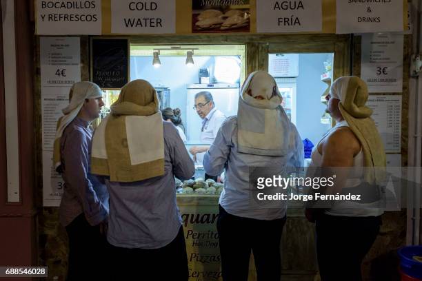 Coistaleros buying drinks and food during a break."Costaleros" are the people in charge of carrying the heavy pasos or images used during the Easter...