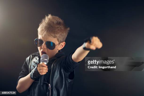 kleiner junge singt rock - child on stage stock-fotos und bilder