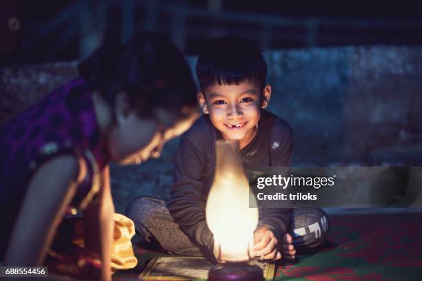 boy and girl studying in oil lamp - india poverty stock pictures, royalty-free photos & images