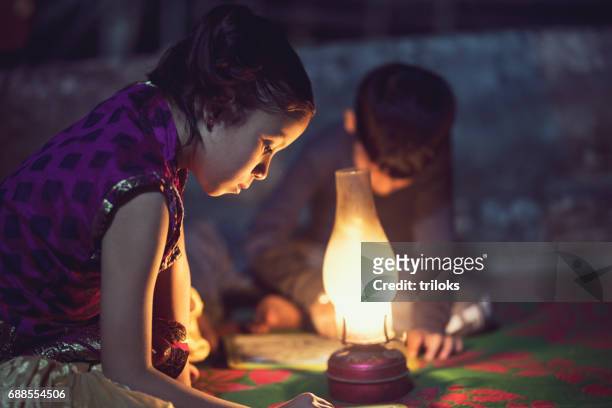 garçon et fille étudie à la lampe à huile - children oil lamp study photos et images de collection
