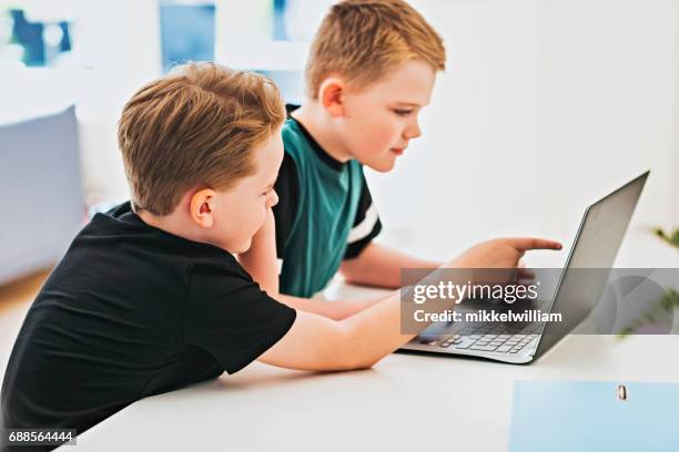 bambini che lavorano insieme davanti al computer portatile - danimarca foto e immagini stock