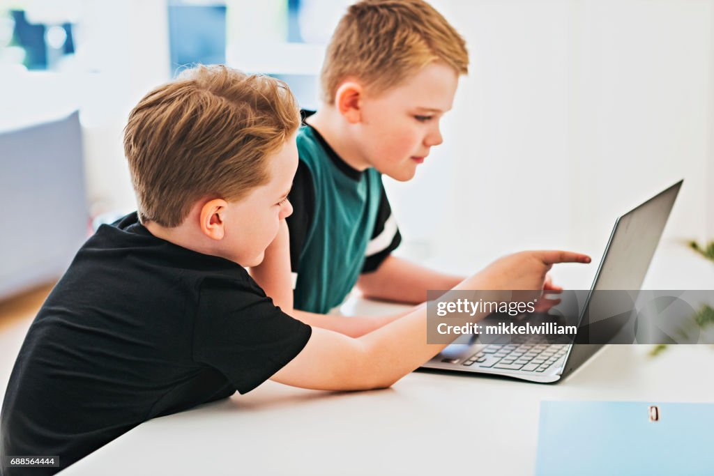 Kinderen werken samen voor laptopcomputer