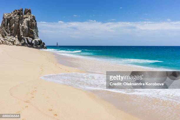 rock formations and white sandy beach around the arch in cabo san lucas, mexico. - baja california sur fotografías e imágenes de stock