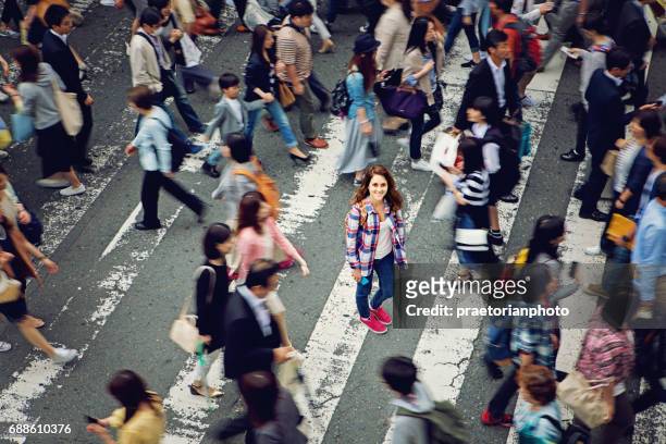 young caucasian girl is smiling confused losted in tokyo crowd - crowd of people stock pictures, royalty-free photos & images
