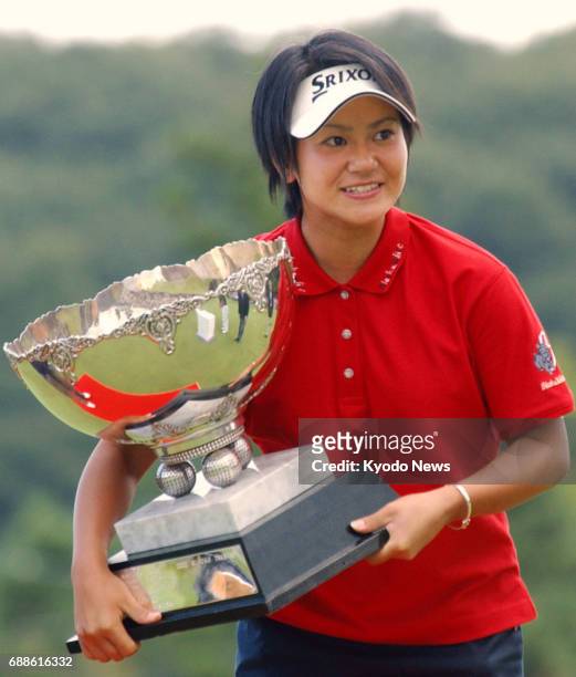 File photo taken in September 2003 shows Japanese golfer Ai Miyazato holding the trophy after winning the Miyagi TV Cup Dunlop Ladies Open in Rifu,...