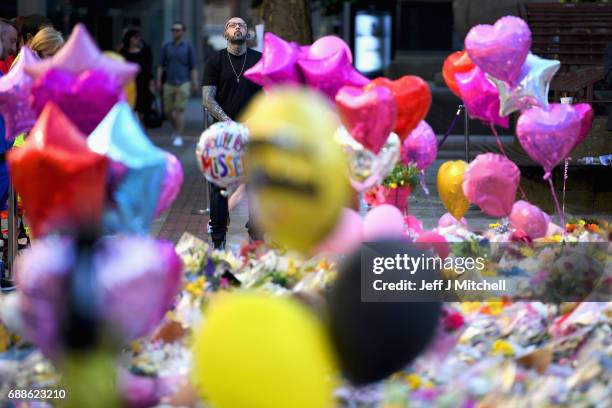 Members of the public look at tributes left in St Ann's Square for the people who died in Monday's terror attack at the Manchester Arena on May 26,...