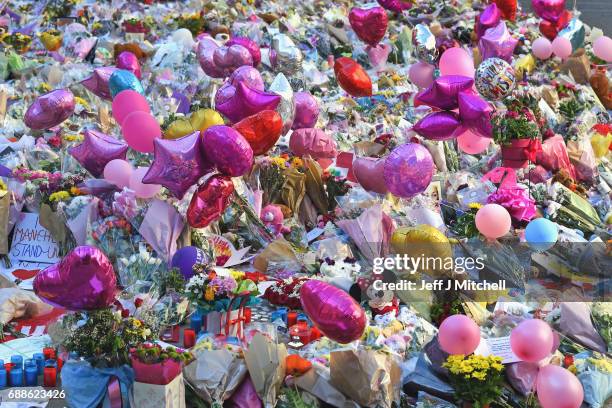 Members of the public look at tributes left in St Ann's Square for the people who died in Monday's terror attack at the Manchester Arena on May 26,...