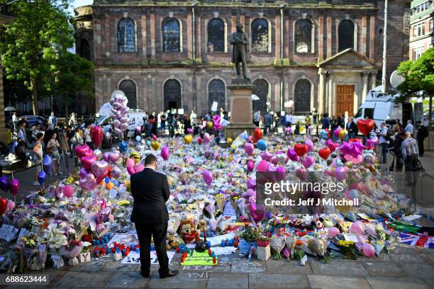 Members of the public look at tributes left in St Ann's Square for the people who died in Monday's terror attack at the Manchester Arena on May 26,...
