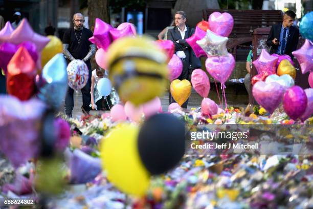 Members of the public look at tributes left in St Ann's Square for the people who died in Monday's terror attack at the Manchester Arena on May 26,...