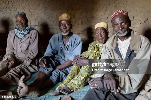 Group of the elders of Yaka inside the hut where the keep the knifes for the circumcision ceremony. They are the ones in charge of organising the...