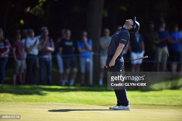 South African golfer Branden Grace reacts after putting on the first green on the second day of the golf PGA Championship at Wentworth Golf Club in...