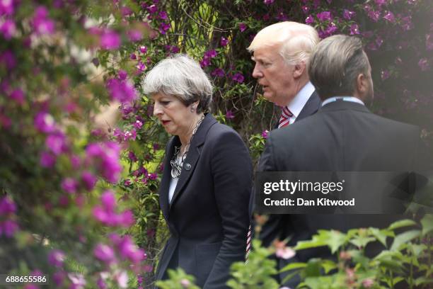British Prime Minister Theresa May and U.S. President Donald Trump walk together in the grounds of the San Domenico Palace Hotel as they attend a...