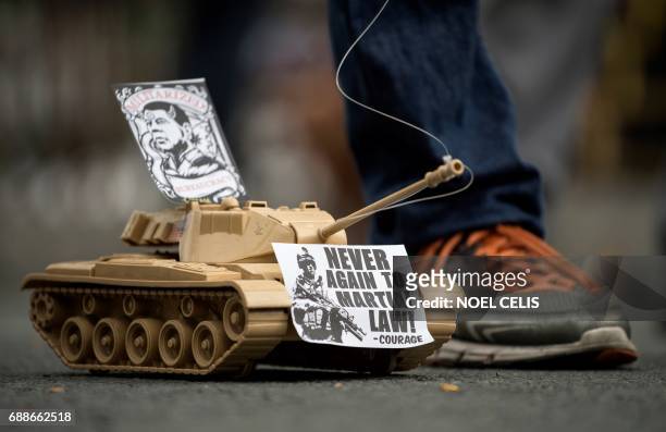 Toy tank with anti-martial law slogans is seen as activists to Mendiola near the Malacanang Palace in Manila on May 26 condemning the government's...