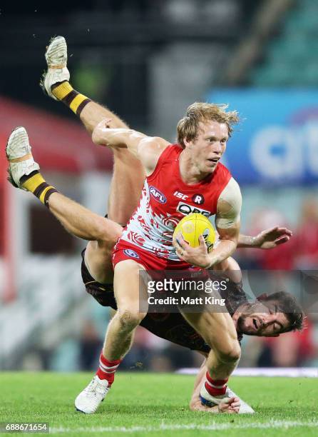 Callum Mills of the Swans is challenged by Ricky Henderson of the Hawks during the round 10 AFL match between the Sydney Swans and the Hawthorn Hawks...