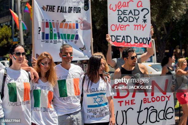 Israeli anti-fur activists hold banners as they participate in an event initiated by the international Anti-Fur coalition to ask for the dissolution...