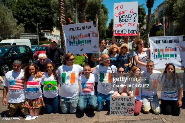 Israeli anti-fur activists hold banners as they participate in an event initiated by the international Anti-Fur coalition to ask for the dissolution...