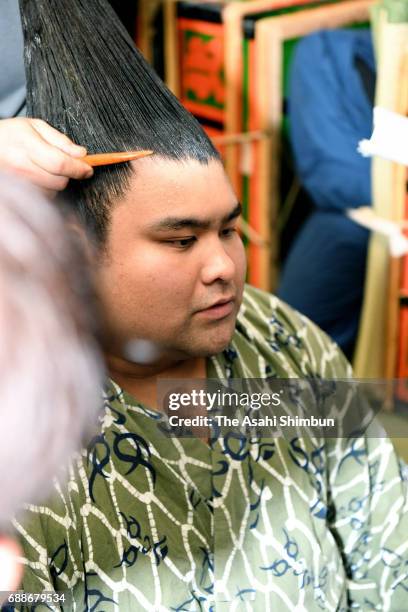 Sekiwake Takayasu responds a question while having his topknot arranged after his victory over Mongolian yokozuna Harumafuji in the dressing room...