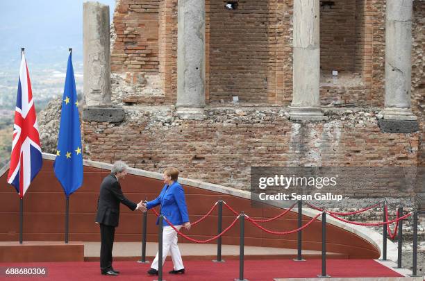 Italian Prime Minister Paolo Gentiloni welcomes German Chancellor Angela Merkel in the ancient amphiteater at the G7 Taormina summit on the island of...