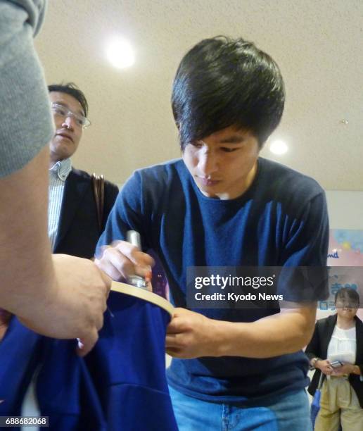 Kohei Kato, midfielder for Bulgarian club Beroe Stara Zagora, signs an autograph for a fan at Tokyo's Haneda airport on May 26 after being called up...