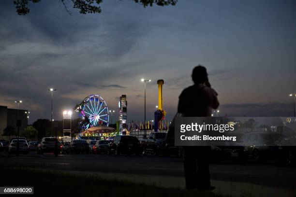 Shopper stands near the Dreamland Amusements carnival in the parking lot of the Marley Station Mall in Glen Burnie, Maryland, U.S., on Friday, April...