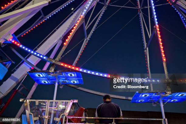 Ride operator stands at the Dream Wheel during the Dreamland Amusements carnival in the parking lot of the Marley Station Mall in Glen Burnie,...