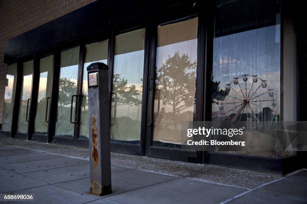 The Dream Wheel is reflected in the window of a shuttered anchor store during the Dreamland Amusements carnival in the parking lot of the Marley...