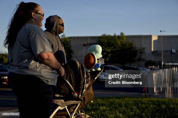 Parents watch their children on an amusement ride during the Dreamland Amusements carnival in the parking lot of the Marley Station Mall in Glen...