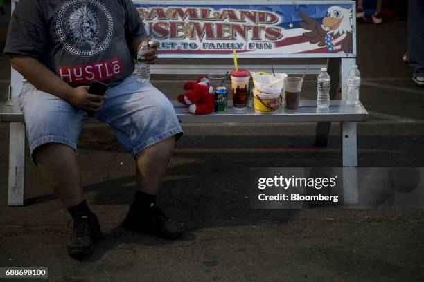 An visitor sits on a bench during the Dreamland Amusements carnival in the parking lot of the Neshaminy Mall in Bensalem, Pennsylvania, U.S., on...