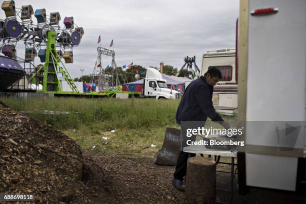 Man prepares a meal near carnival rides in the parking lot of the Neshaminy Mall in Bensalem, Pennsylvania, U.S., on Saturday, May 20, 2017. As mall...