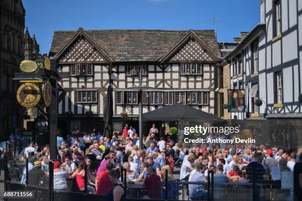 People enjoy the warm weather outside Sinclair's Oyster Bar close to the Manchester Arena in central Manchester on May 26, 2017 in Manchester,...