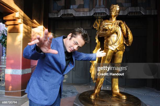 In this handout photo provided by Disney Parks, Benicio del Toro poses with the statue of his Guardians character, 'The Collector' at the grand...