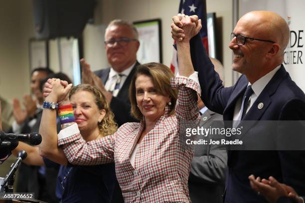 House Minority Leader Rep. Nancy Pelosi , Rep. Debbie Wasserman Schultz and Rep. Ted Deutch raise their arms together as they attend a discussion...