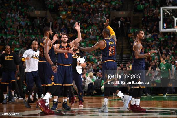 LeBron James high fives Kevin Love and Tristan Thompson of the Cleveland Cavaliers during the game against the Boston Celtics in Game Five of the...