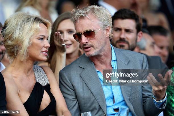 Former F1 driver Eddie Irvine talks with Pamela Anderson at the Amber Lounge fashion show during previews to the Monaco Formula One Grand Prix at...