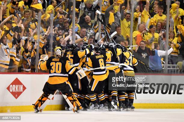The Pittsburgh Penguins celebrate after Chris Kunitz scored the game winning goal against Craig Anderson of the Ottawa Senators in the second...