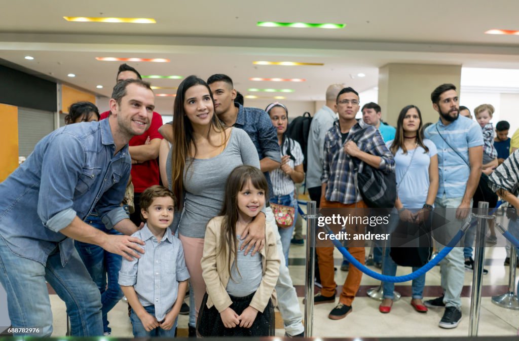 Familia feliz en línea para comprar boletos en el cine