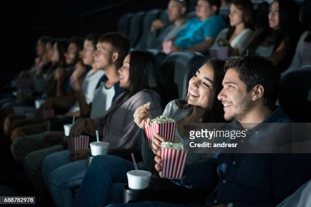 felice coppia latinoamericana al cinema - film foto e immagini stock