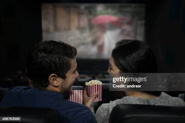 lyckliga paret på bio äta popcorn och ha roligt - couple watching a movie bildbanksfoton och bilder