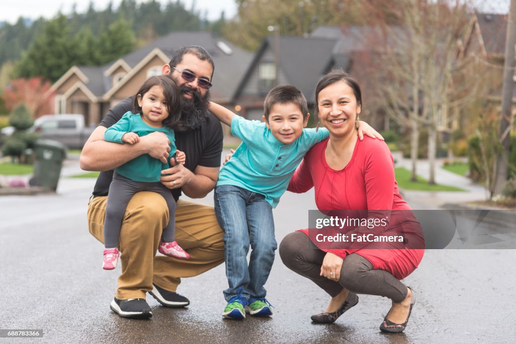 Two Native American parents and their children take a family walk through their suburban neighborhood