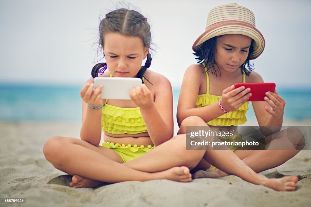 在衝突中的姐妹坐在海灘，生悶氣彼此