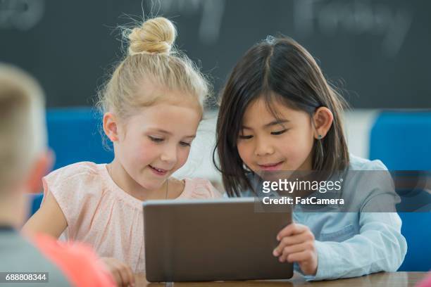 learning together on a digital tablet - elementary school building stock pictures, royalty-free photos & images
