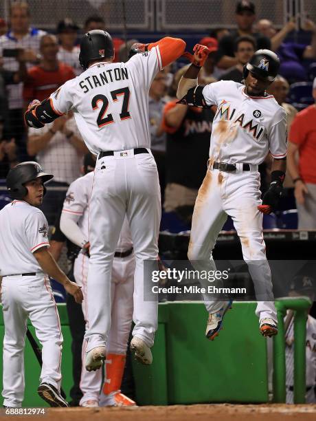 Giancarlo Stanton of the Miami Marlins is congratulated by Dee Gordon after hitting a two run home run in the first inning during a game against the...