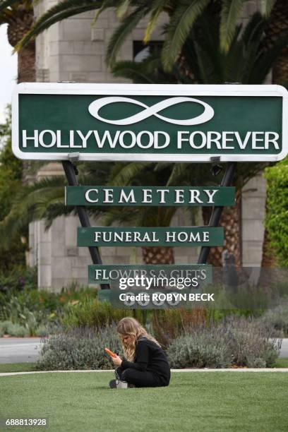 Girl sits outside Hollywood Forever Cemetery before the funeral and memorial service for Soundgarden frontman Chris Cornell, May 26, 2017 in Los...