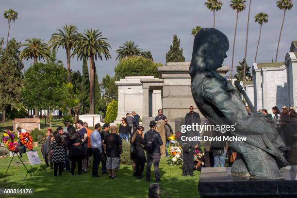 Grieving fans gather at the grave of Chris Cornell, near a memorial statue on the grave of Johnny Ramone, of the band The Ramones, after funeral...