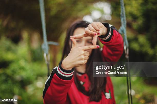 young woman in red making square frame with fingers - fingerrahmen stock-fotos und bilder