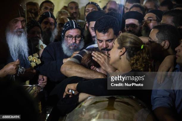 Relatives of Coptic Christians who were killed during a bus attack, surround their coffins, during their funeral service, at Ava Samuel desert...