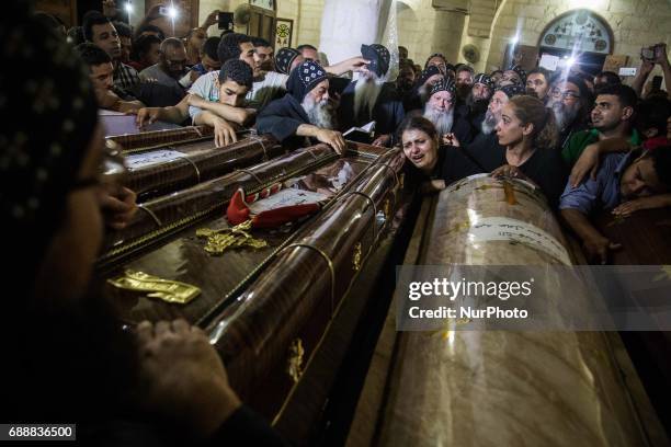 Relatives of Coptic Christians who were killed during a bus attack, surround their coffins, during their funeral service, at Ava Samuel desert...