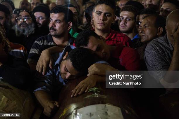 Relatives of Coptic Christians who were killed during a bus attack, surround their coffins, during their funeral service, at Ava Samuel desert...
