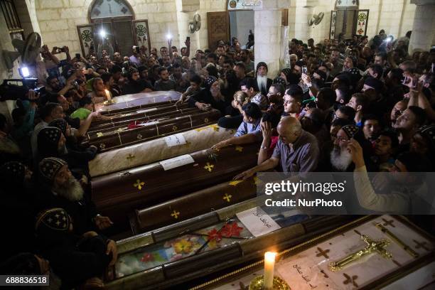 Relatives of Coptic Christians who were killed during a bus attack, surround their coffins, during their funeral service, at Ava Samuel desert...