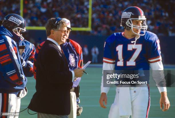 Head Coach Dan Reeves of the New York Giants talks with quarterback Dave Brown on the sidelines during an NFL football game circa 1995 at Giants...
